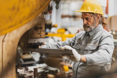 Üst düzey mühendis kalite kontrol için ürün arıyor. Metal levha fabrikasında profesyonel iş..