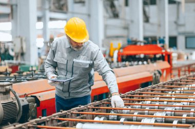 Profesyonel kıdemli sanayi işçisi koruyucu miğfer ve fabrikada üniforma servis makineleri, uzman mühendis teknisyen bakım ağır makine üretim hattı