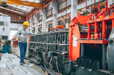 Profesyonel kıdemli sanayi işçisi koruyucu miğfer ve fabrikada üniforma servis makineleri, uzman mühendis teknisyen bakım ağır makine üretim hattı
