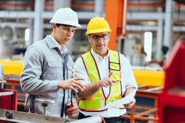 Profesyonel kıdemli mühendis eğitimi, çalışan iki işçi, çelik endüstrisi fabrikasında genç bir mühendisle çalışan teknisyen..