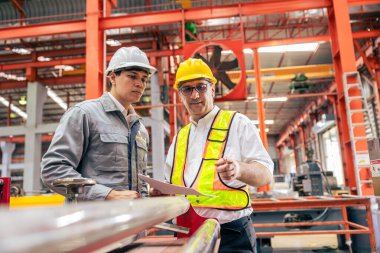 Profesyonel kıdemli mühendis eğitimi, çalışan iki işçi, çelik endüstrisi fabrikasında genç bir mühendisle çalışan teknisyen..