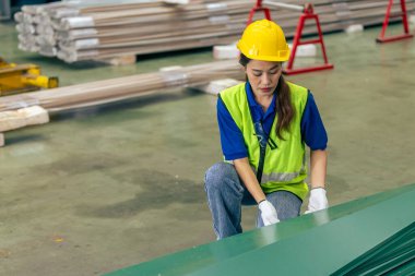 Asyalı kadın mühendis, profesyonel çalışan. Metal levha fabrikasında ürün envanterini kontrol ediyor.