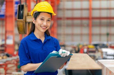 Genç Asyalı kadın mühendis gülümseyen profesyonel işçi metal levha fabrikasında çalışıyor, güvenlik teknisyeni.