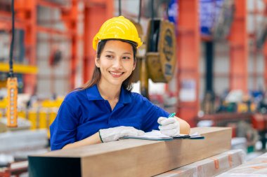 Genç Asyalı kadın mühendis gülümseyen profesyonel işçi metal levha fabrikasında çalışıyor, güvenlik teknisyeni.