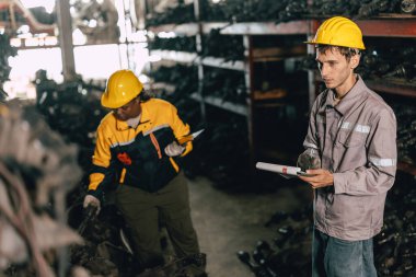 Mühendis personeli olan Afrikalı kadınlar birlikte çalışıyorlar. Ağır endüstri, eski, kullanılmış metal makine, yarı stok deposu..
