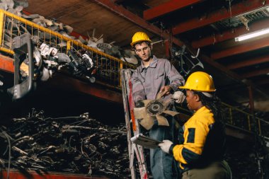 Mühendis personeli olan Afrikalı kadınlar birlikte çalışıyorlar. Ağır endüstri, eski, kullanılmış metal makine, yarı stok deposu..