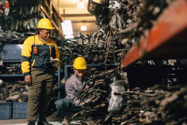 Mühendis personeli olan Afrikalı kadınlar birlikte çalışıyorlar. Ağır endüstri, eski, kullanılmış metal makine, yarı stok deposu..