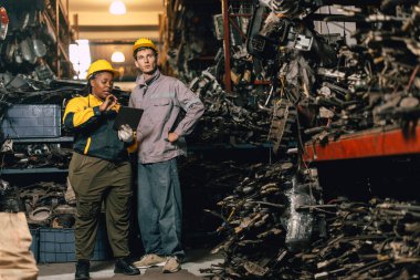 Mühendis personeli olan Afrikalı kadınlar birlikte çalışıyorlar. Ağır endüstri, eski, kullanılmış metal makine, yarı stok deposu..