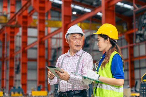 Metal levha fabrikasında kıdemli yönetici ile fabrika fabrikasında çalışan kadın işçi.