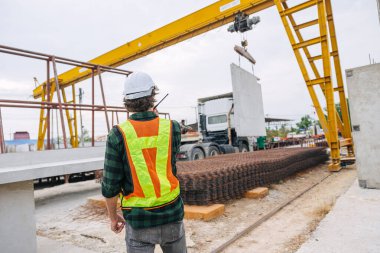 Beton precast fabrika kontrolünde çalışan profesyonel mühendis erkek inşaat alanında vinç kaldırıyor. .