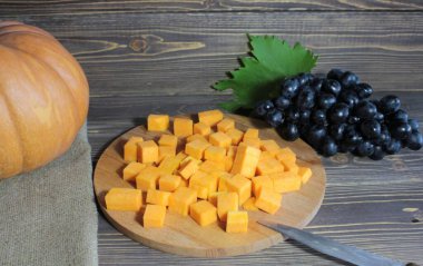 Kahverengi ahşap arka planda balkabağı ve balkabağı parçaları.