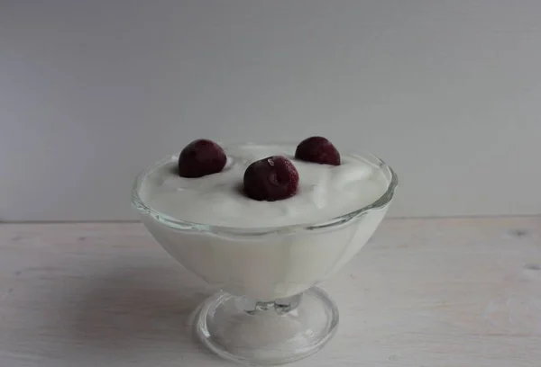 Iogurte Com Cerejas Uma Tigela Vidro Uma Superfície Madeira Leve — Fotografia de Stock