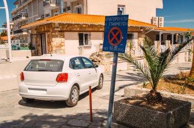 Araba park yasaklayan bir işaret altında duruyor.