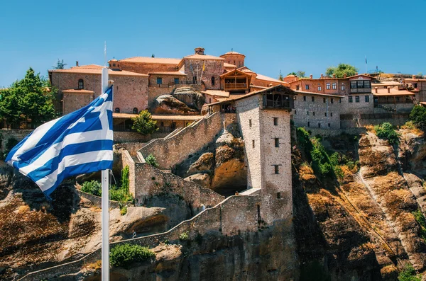 Řecká vlajka před The Holy Monastery z velké Meteoron Meteora - komplex pravoslavných klášterů na horách, Thesálie, Řecko — Stock fotografie