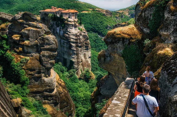 Menschen gehen auf den Hintergrund des heiligen Klosters von Varlaam. meteora klöster, griechenland — Stockfoto