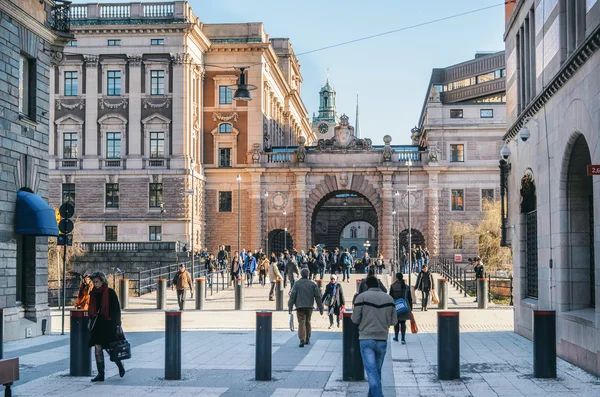 La gente camina por la calle Drottninggatan en un fondo del Arco del Parlamento Riksdag . — Foto de Stock