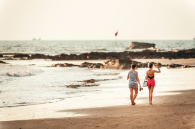 İki kadın bir plaj Goa, Hindistan boyunca yürüyüş