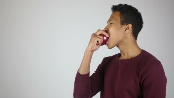 Manger des pommes rouges fraîches, mâcher jeune homme affamé — Video