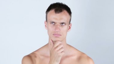 Kameraya bakarak bir düşünceli gömleksiz yakışıklı genç portresi