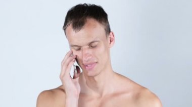Neşeli yakışıklı gömleksiz adam telefonda konuşurken portresi