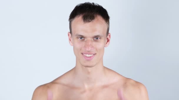 Retrato de hombre joven sin camisa muestra los pulgares hacia arriba con ambas manos — Vídeo de stock