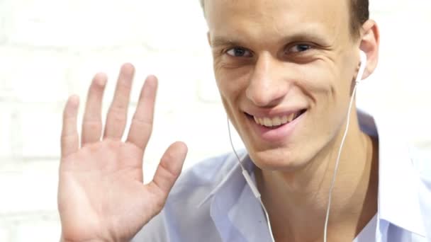 Hombre teniendo videollamada con tableta y auriculares — Vídeos de Stock