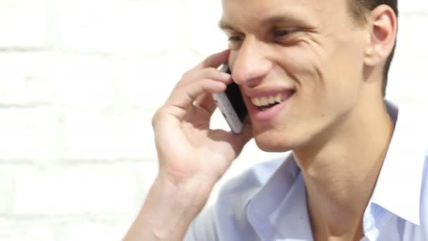 Νεαρός χαμογελαστό επιχειρηματίας, μιλώντας στο smartphone σε κοντινό πλάνο — Αρχείο Βίντεο