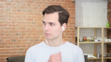 Onun favori müzik keyfi. Neşeli genç adam dinlerken kulaklık