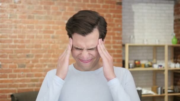 У молодого отчаявшегося человека головная боль, стресс от фрустрации — стоковое видео