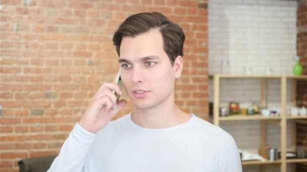 Šťastný úspěšný mladý muž mluví do mobilního telefonu — Stock video
