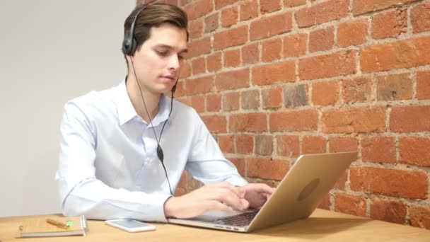 Weergave van een aantrekkelijke jongeman bezig met laptop opdagen duimen, callcenter — Stockvideo