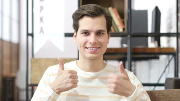 Молодой человек подает большой палец в знак успеха — стоковое видео