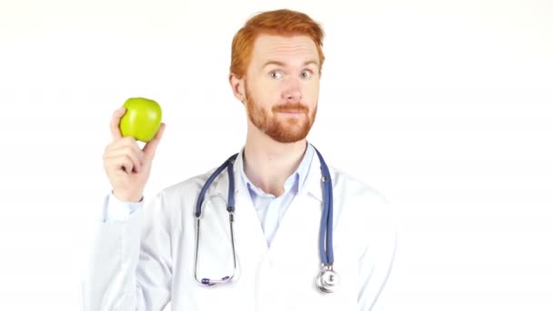 Leende läkare visar grönt äpple till kameran — Stockvideo