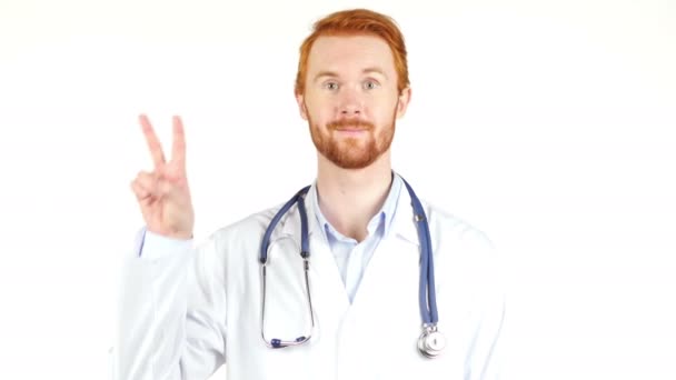 Retrato del médico mostrando signo de victoria sobre fondo blanco — Vídeo de stock