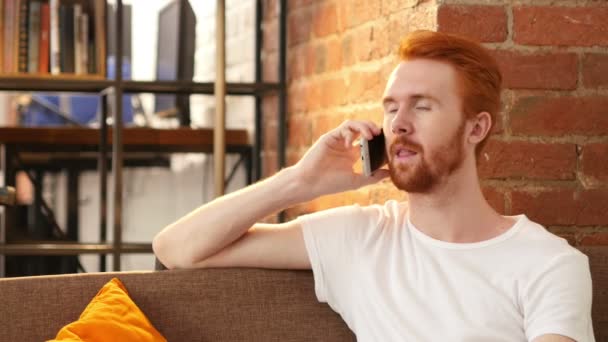 Sorrindo feliz cabelo vermelho homem recebendo boas notícias no telefone — Vídeo de Stock