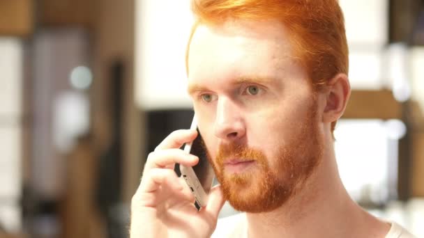 Junger und gesunder Mann lächelt und telefoniert zu Hause auf dem Smartphone — Stockvideo