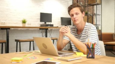 Loft ofiste iş başında yaratıcı adam gülümsüyor, iş ile memnun