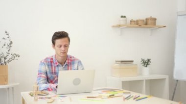 Onun laptop yaratıcı ofis, meşgul yeni proje üzerinde çalışan mutlu tasarımcı