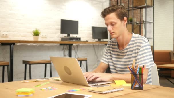 Hombre escribiendo en el teclado del ordenador portátil en la oficina moderna Loft — Vídeos de Stock