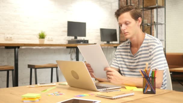 Jovem Designer Lendo Papelada na Mesa no Escritório Loft — Vídeo de Stock