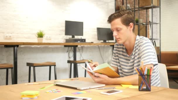 Joven escritura masculina en cuaderno con pluma, Modern Loft Office — Vídeo de stock