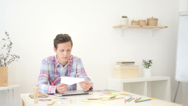 Jonge man houden papier vliegtuig, denken van een idee — Stockvideo