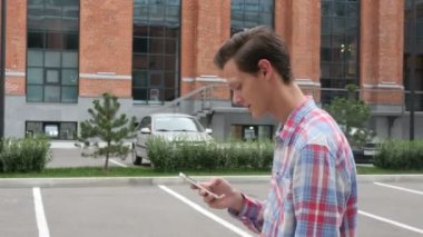 Smartphone, yan görünümü kullanan yürüyen adam