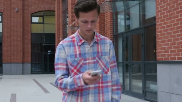 Wandelen Man te typen bericht op Smartphone, vooraanzicht — Stockvideo