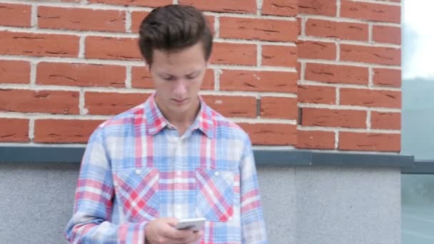 Stående av en mur, mannen med Smartphone — Stockvideo