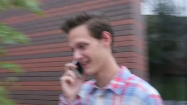 Izgatott a sétáló ember beszél telefonon, séta a parkoló — Stock videók