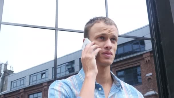 Чоловік, який відвідує телефонний дзвінок, стоячи зовні, розмовляти — стокове відео
