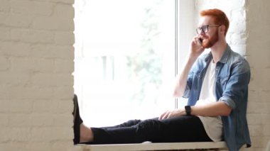 Yanıtlayan telefon görüşmesi, konuşma penceresi, kırmızı saç ve sakal oturan tasarımcı