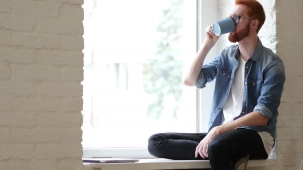 Nachdenklicher Mann trinkt Kaffee, Tee, sitzt entspannt im Fenster — Stockvideo