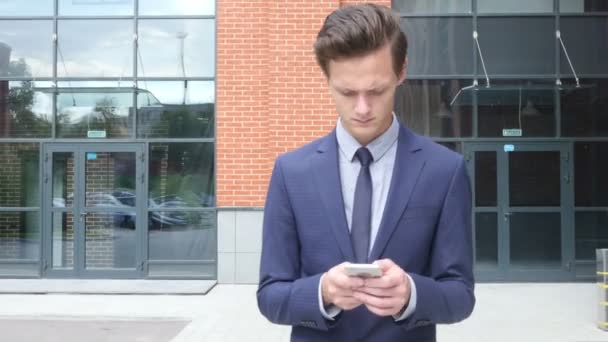 Pěší podnikatel psát textovou zprávu na chytrém telefonu, e-mailem, venkovní — Stock video